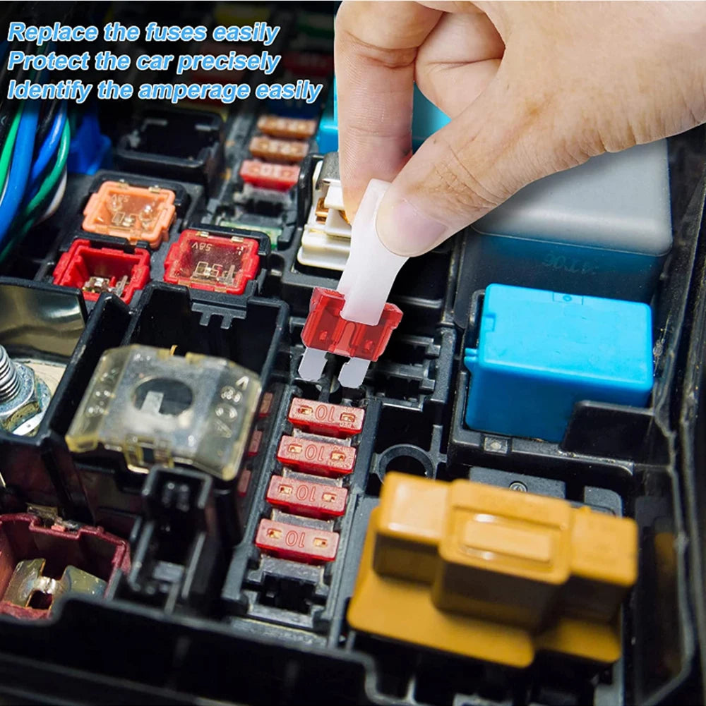 Close-up of a car's fuse box with a hand holding a fuse identifier tool.